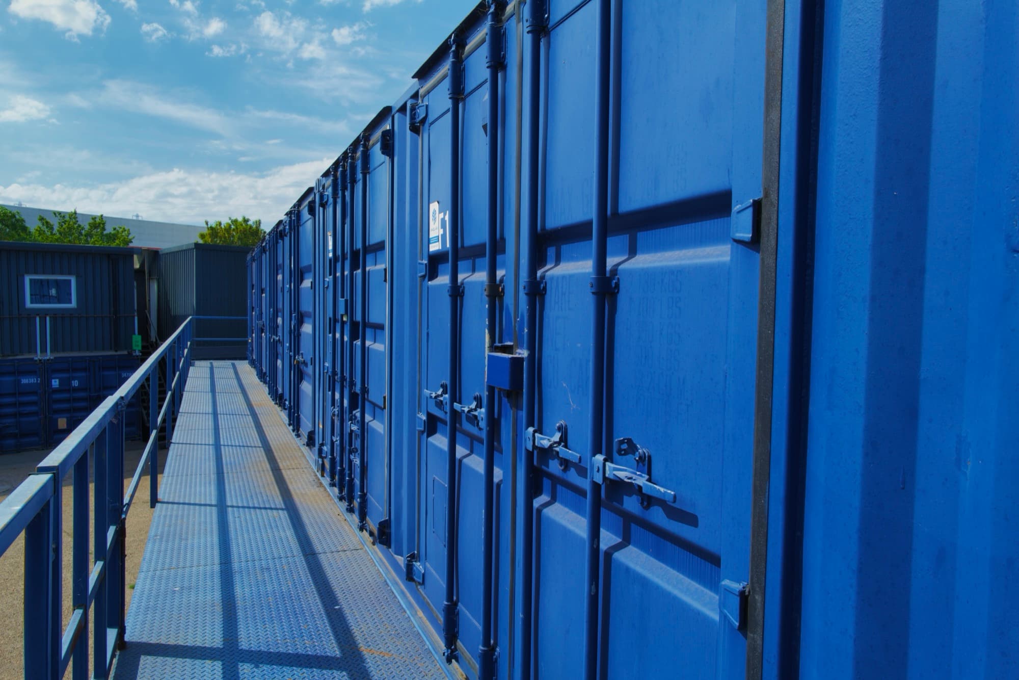 Elevated walkway between storage containers for ecommerce inventory